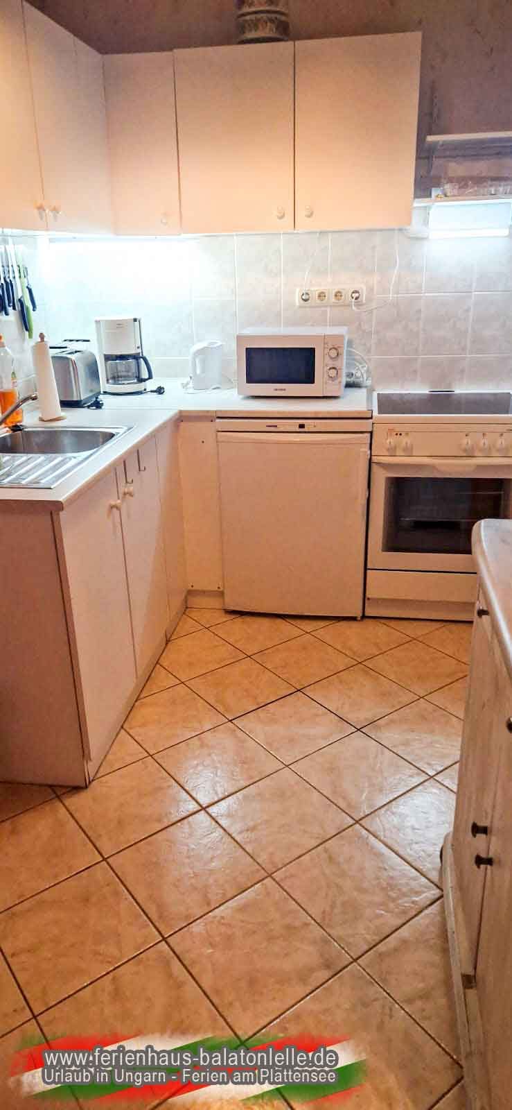 Küche im Ferienhaus Balatonlelle mit Herd, Kühlschrank, Mikrowelle, Toaster und Kaffeemaschine